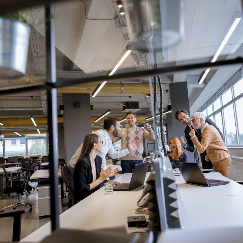 happy-young-business-people-standing-in-the-office-and-looking-forward-to-success-in-the-office.jpg